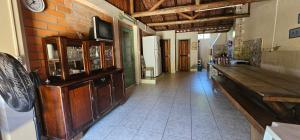 a living room with a tv on a brick wall at Cantinho de Zimbros in Bombinhas