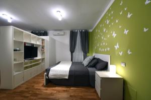 una camera con letto e parete verde con farfalle di Jubilee 1 a Roma