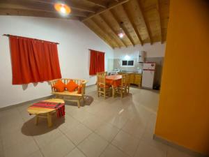 a living room with a table and a kitchen at Casitas Del Champaqui in Villa Yacanto