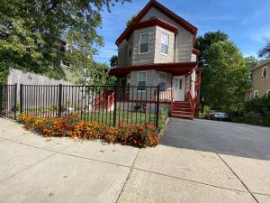 a house with a fence and flowers in front of it at Kailyn Apartment Boston, Massachusetts in Boston
