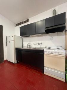 a kitchen with a stove and a white refrigerator at Casa a 1 cuadra del Río San Antonio in San Antonio de Arredondo