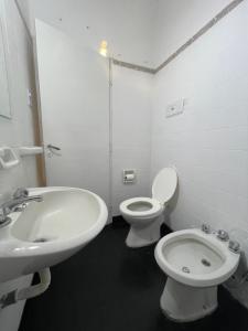 a white bathroom with a sink and a toilet at Casa a 1 cuadra del Río San Antonio in San Antonio de Arredondo
