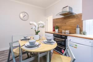 eine Küche mit einem Tisch und Geschirr darauf in der Unterkunft Medway, Rochester Stays Living - Contractors, Family, Free Parking, Garden, Sleeps up to 6 guests in Wainscot + 29 Fotos