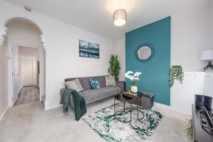 ein Wohnzimmer mit einer Couch und einer blauen Akzentwand in der Unterkunft Medway, Rochester Stays Living - Contractors, Family, Free Parking, Garden, Sleeps up to 6 guests in Wainscot