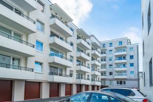 an apartment building with cars parked in front of it at Apartmenthaus Dünenburg Dünenburg App 31 in Westerland (Sylt)
