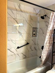 a bathroom with a tub and a marble wall at Spacious Desert Getaway Scenic Views Hammock in Marana +22 photos