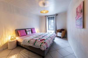 - une chambre avec un grand lit et des oreillers roses dans l'établissement Séjour lodge Namur, à Namur