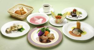 una mesa con platos de comida y una taza de café en Chuzenji Kanaya Hotel, en Nikko