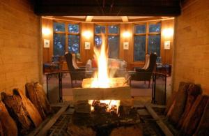 a fire pit in a room with chairs and a table at Chuzenji Kanaya Hotel in Nikko