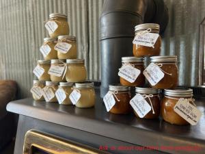 a group of jars of honey on a table at Butterfly Cottage - open air eco villa in Oliver