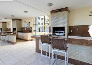 a large kitchen with a bar and chairs in it at Hospedagem Executiva Águas Claras in Brasília