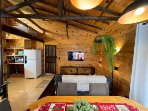 a living room with a table and a refrigerator at Casa da Colina - Campo Novo in Bom Retiro