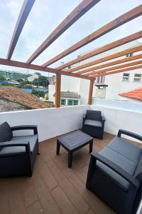 a patio with chairs and tables on a roof at Casa do Chafariz Velho in Angra do Heroísmo