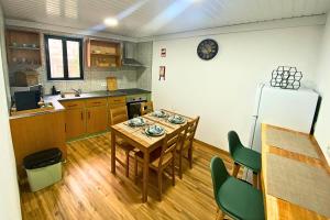 a kitchen with a table and chairs and a refrigerator at Casa do Chafariz Velho in Angra do Heroísmo +16 photos
