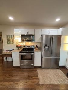 une cuisine avec des appareils en acier inoxydable et des armoires blanches dans l'établissement The Baby House of Greenville, à Greenville