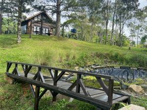 a wooden bench sitting in front of a house at Cabana Trinca Ferro in São Pedro de Alcântara