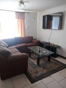 a living room with a couch and a coffee table at Casa Centrica Pucón in Pucón