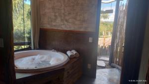 a bath tub in a bathroom with a window at Chalés Fenix in Santo Antônio do Pinhal