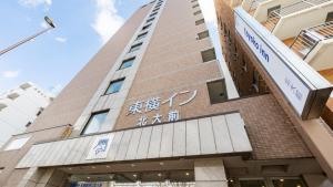 a tall building with chinese writing on it at Toyoko Inn Hokkaido Sapporo-eki Nishi-guchi Hokudai Mae in Sapporo +40 photos
