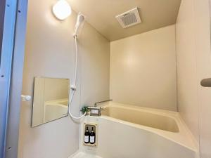 a bathroom with a shower with a mirror and a tub at ロイヤル黒部 in Kurobe +16 photos