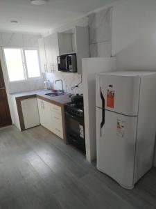 a kitchen with a white refrigerator and a stove at Departamentos Santa Clara del Mar Bilbao PB in Santa Clara del Mar