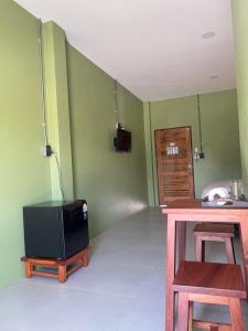 Ban Chuk KumThe Duck House的绿墙客房内的小电视 更多21张照片