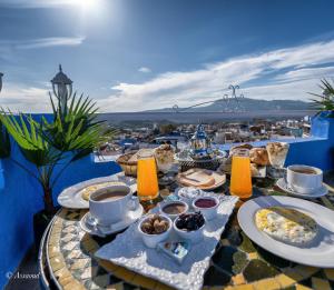 a table with breakfast food on top of a house at Dar Bleumain in Chefchaouen