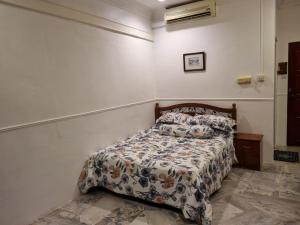 a bedroom with a bed with a comforter on it at D'Imar Homestay - Homestay Serendah in Serendah