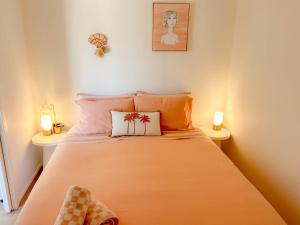 een slaapkamer met een bed met oranje lakens en 2 lampen bij Villa Nura in Lake Illawarra +32 foto's