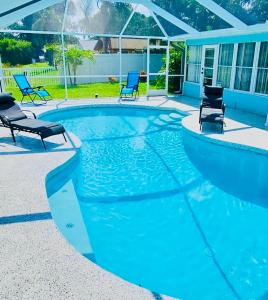 布雷登顿NEW Renovated luxury home with private heated pool, game room Near Anna Maria Island and IMG的一个带两把椅子的游泳池