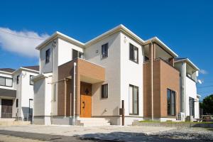 una grande casa bianca con una porta marrone di Inamine Terrace K a Nago