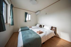 una stanza con due letti e una finestra di Inamine Terrace K a Nago