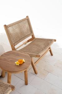 a wicker chair and a wooden table and a tableablish at Villa Casamo in Bali in Badung