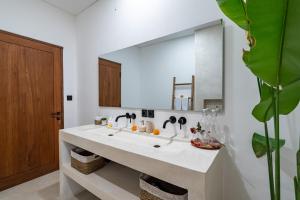 a bathroom with a sink and a large mirror at Villa Casamo in Bali in Badung
