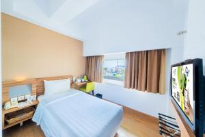 Postel nebo postele na pokoji v ubytování Whiz Prime Hotel Balikpapan
