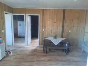 a living room with a table and a room with wooden walls at Servidão 1619 in Palhoça