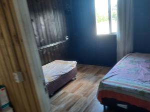 a small bedroom with a bed and a window at Servidão 1619 in Palhoça