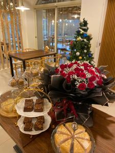 ein Tisch mit Weihnachtsessen und ein Weihnachtsbaum in der Unterkunft Kilar Mountain Villa in Zeren