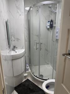 Un baño con ducha, lavabo e inodoro. en Luxury Studio in Victoria, 7 minutes walk to Victoria Station, Room 2, en Londres