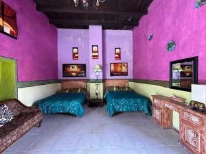 a room with two beds and a pink wall at Hacienda Los Girasoles Siglo XVIII in Huichapan