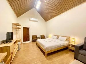 a bedroom with a bed and a tv and a couch at Baan Pong Tara in Suan Phung
