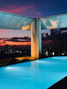 a swimming pool with a view of a city at night at Vinia Residences,Kwarto Luna in Manila