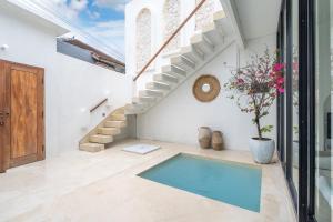 a swimming pool in the middle of a room with stairs at Villa Tropical Nomad at Canggu in Badung