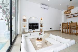 a living room with a white couch and a table at Villa Tropical Nomad at Canggu in Badung