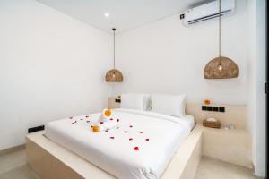 a bedroom with a white bed with flowers on it at Villa Tropical Nomad at Canggu in Badung +16 photos