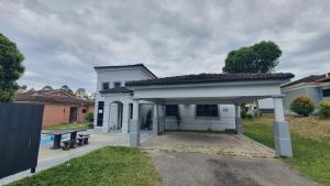 ein weißes Haus mit einer Bank davor in der Unterkunft Lunar Villa A'Famosa Resort by Holiday Pool Villa in Kampong Ulu Pegoh