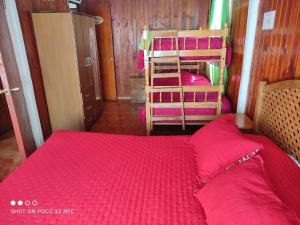 Cabaña el Diuco في كونياريبي: غرفة نوم بسريرين بطابقين مع شراشف حمراء