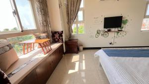 a bedroom with a bed and a tv on the wall at Kinmen Good Friends B&B in An-ch'ien