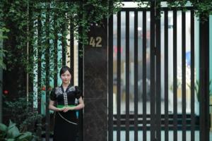 Una mujer está parada frente a una puerta. en Muong Thanh Homestay, en Diện Biên Phủ