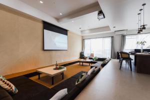 a living room with a couch and a projection screen at ヴィラ Cy MOTOBU 沖縄本部町 一棟貸し in Motobu